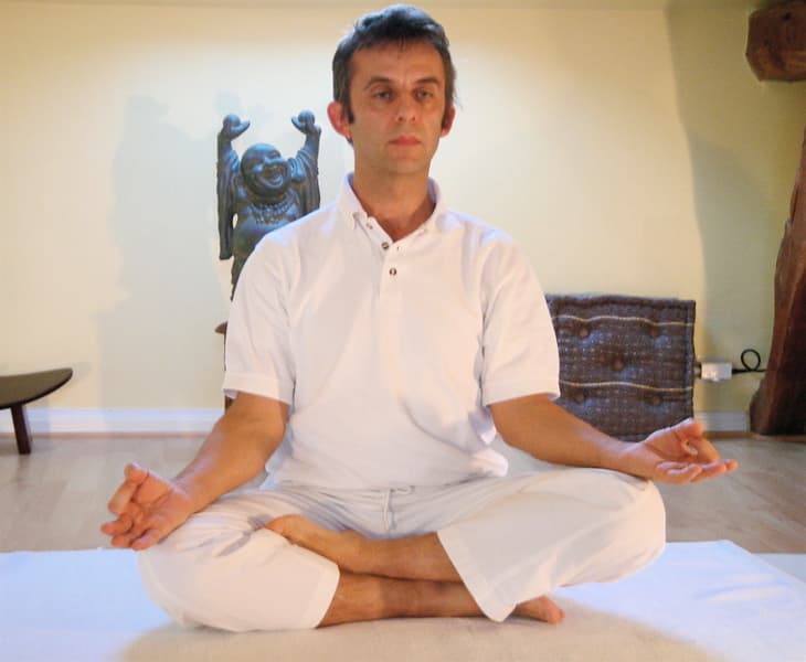 Man sitting cross-legged in Easy Pose with a tall spine and hands resting on his knees